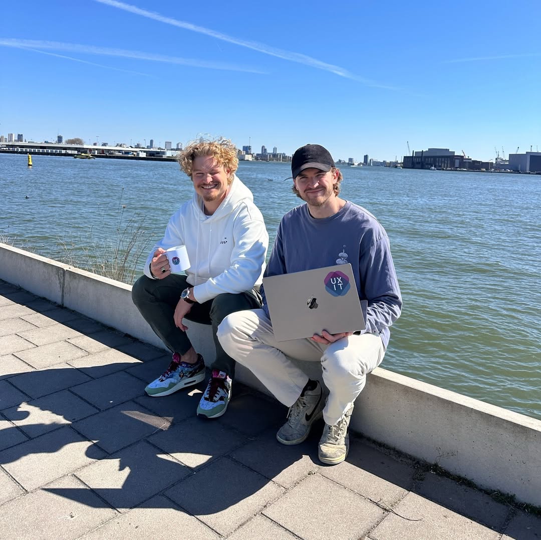 Het team van UXIT aan het water in Rotterdam, met koffie en een laptop